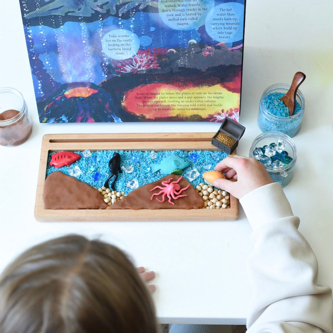 Deep Blue Sea Child with Sea Sensory Play and open Book